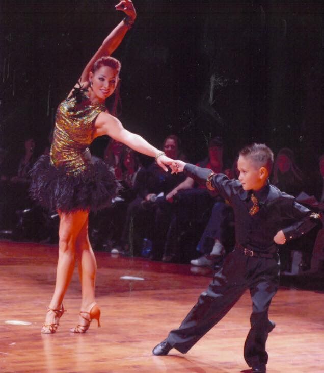 Jaklyn Royal dancing with a young student, encouraging and joyful